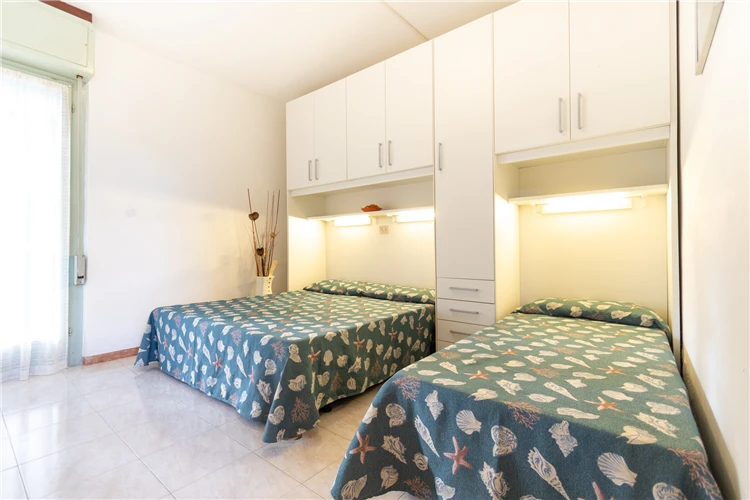 Světlý pokoj vily Sayonara v Lignanu s postelí a oknem | Lignano / Villa Sayonara