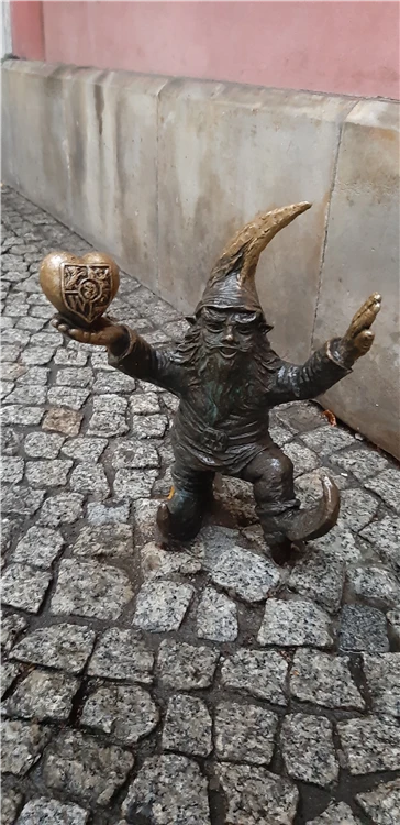 Bronzový trpaslík (krasnal) na dlážděné ulici ve Wroclawi, Polsko | Podmanivá vánoční Vratislav