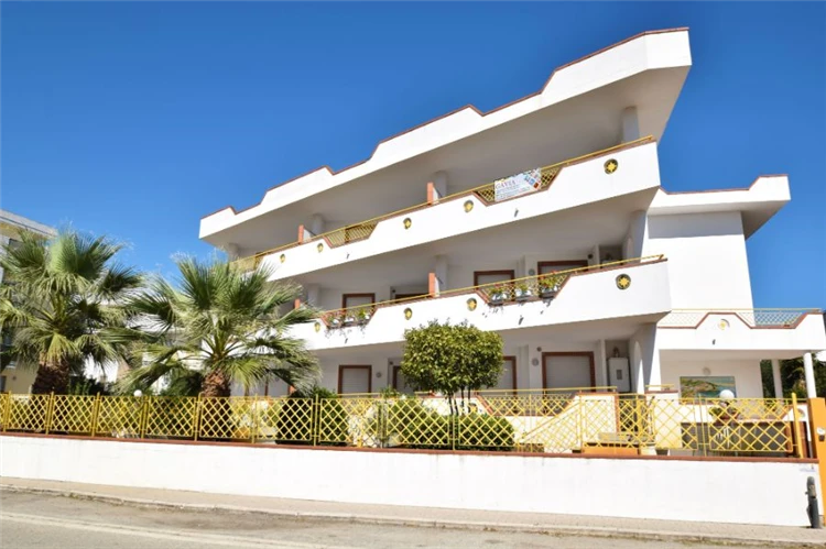 Residence Capri – pohled na budovu obklopenou středomořskou zelení | Villa Rosa / Residence Capri