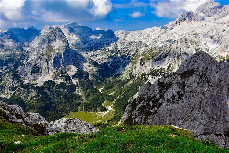 Panoramatický výhled na skalnaté alpské štíty s zeleným údolím v popředí | Slovinsko křížem krážem