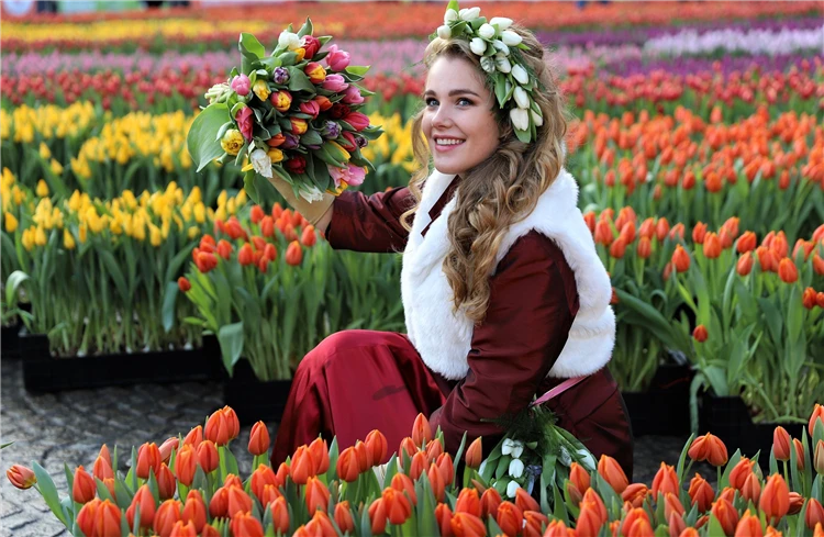 Žena v tradičním holandském kroji s tulipány | Holandsko s květinovým korzem