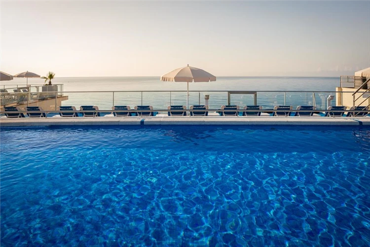 Bazén s lehátky a slunečníky v HTop Pineda Palace | Pineda de Mar / Hotel HTop Pineda Palace