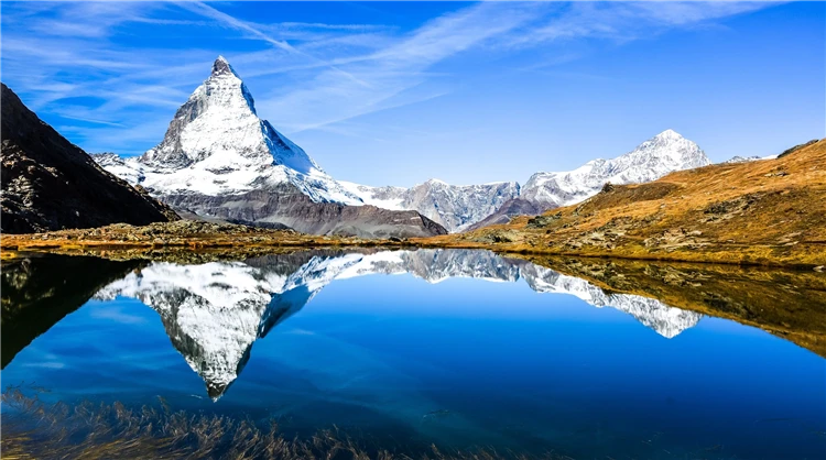 Alpský vrchol se sněhem a dramatickou oblohou ve Švýcarsku | Symbol Švýcarska - legendární Matterhorn a alpské průsmyky