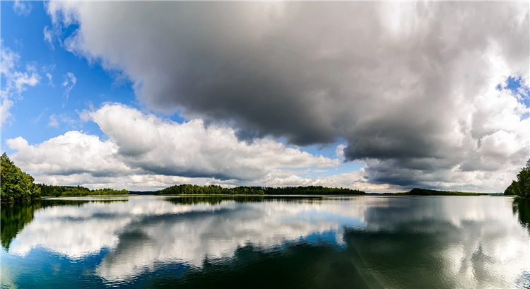 Klidné jezero na Mazurách s odrazem oblohy ve vodě | Mazurská jezera a tajemná jantarová komnata